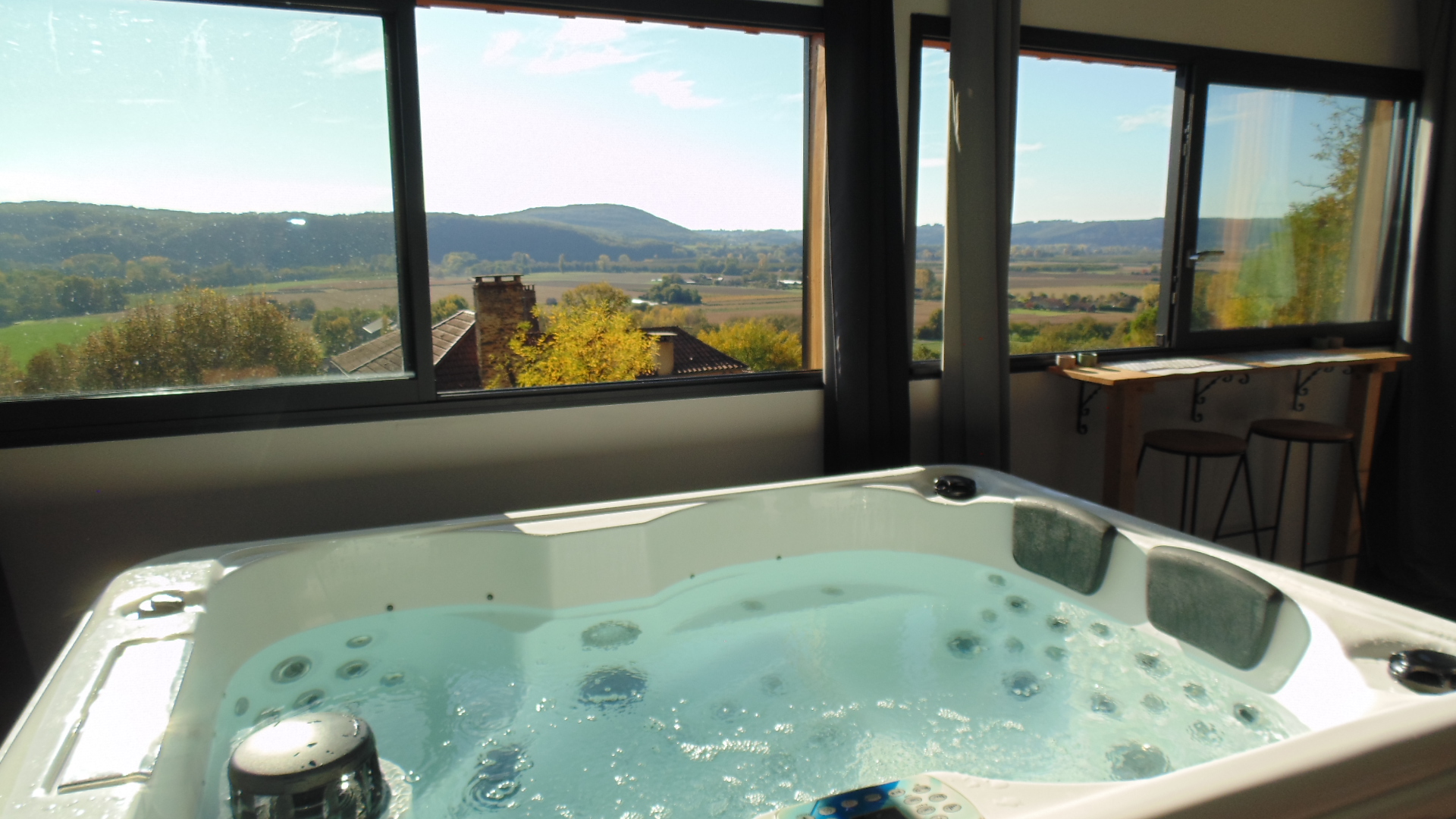 Patio fermé avec son spa privatif et vue sur la Vallée de la Dordogne du chalet La Colombe