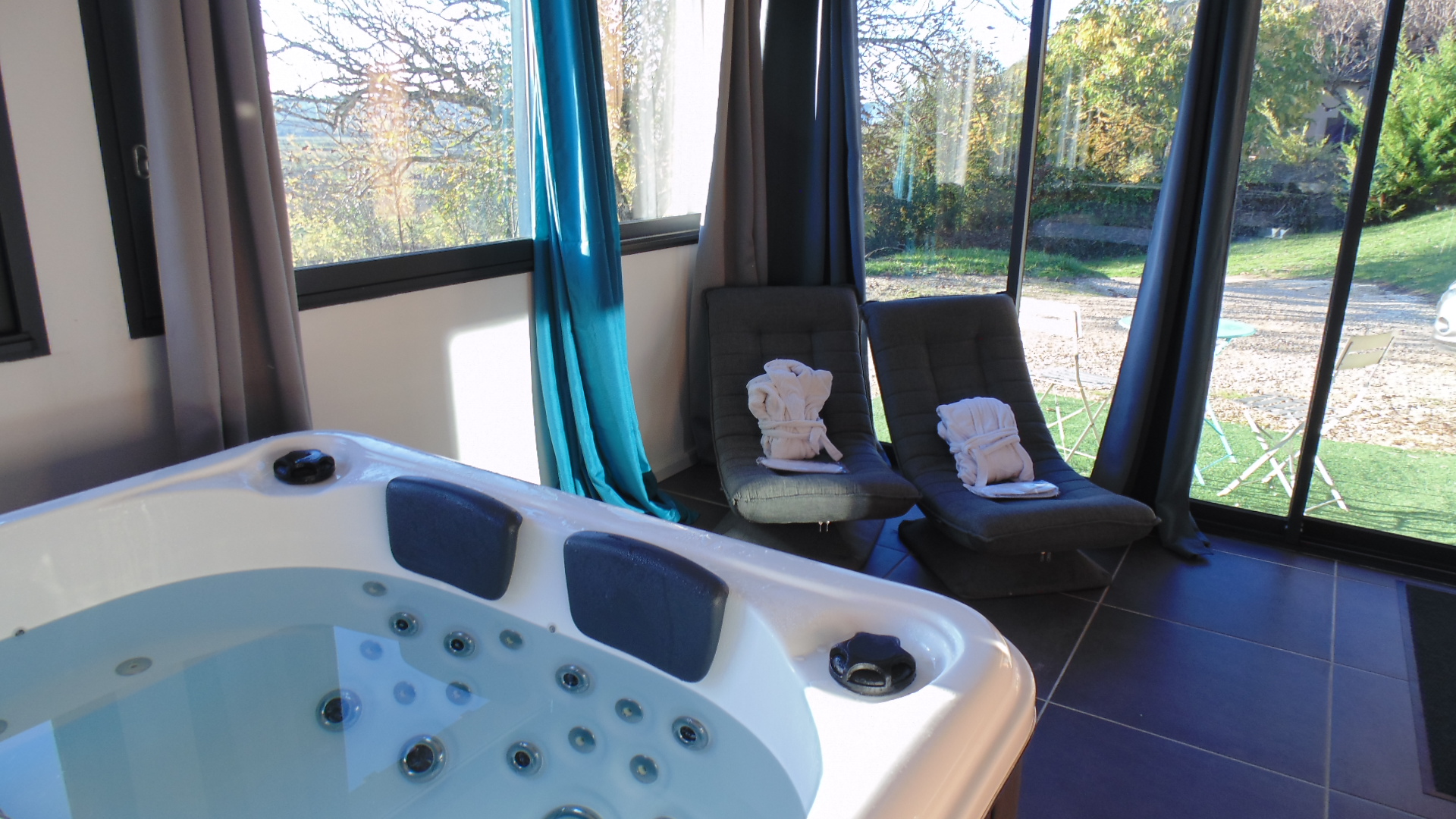 Patio fermé avec son spa privatif et fauteuils détente - Chalet L'Hirondelle